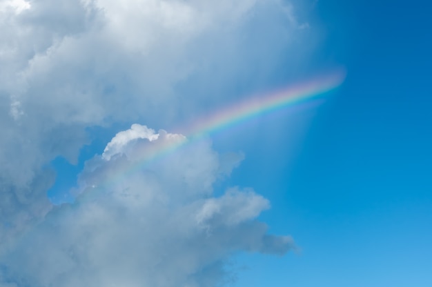 Um arco-íris suave formado nas nuvens em um céu azul conceito feliz