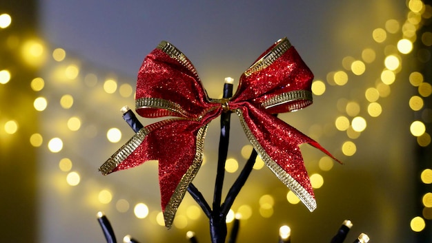 Um arco vermelho festivo em uma árvore de Natal decorativa contra o fundo de lanternas de Natal em novas