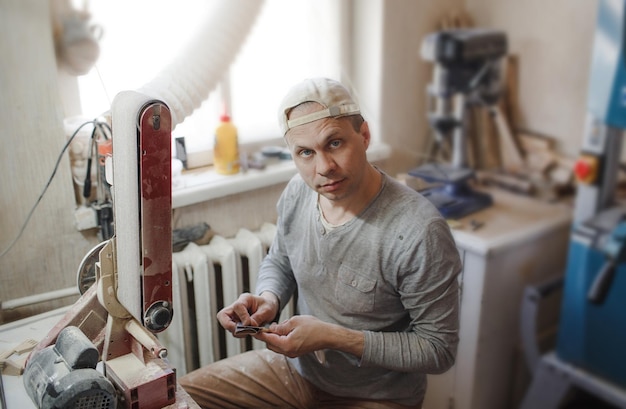 Um artesão masculino faz brinquedos de madeira para crianças em uma oficina de carpintaria