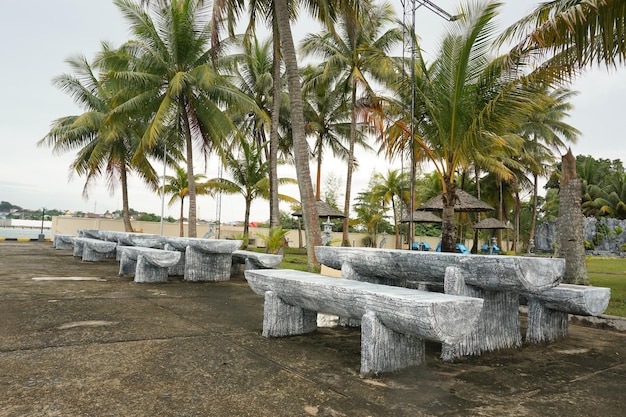 um assento de arte e mesa feitos de cimento esculpido em uma praia