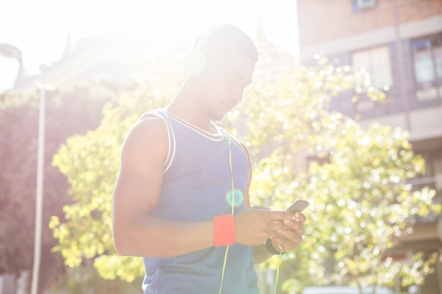 Um atleta bonito usando seu telefone