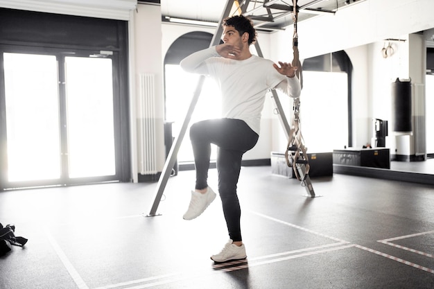 Um atleta do sexo masculino faz exercícios cardio treinando no ginásio