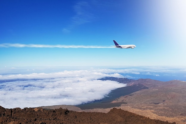 Um avião voa sobre as nuvens e o céu está voando sobre as montanhas.