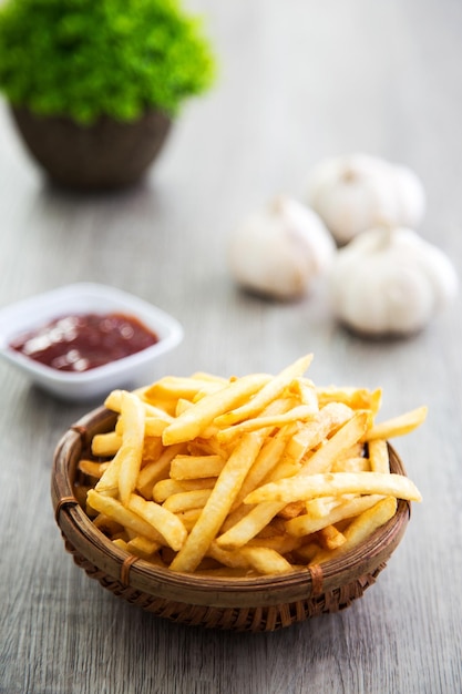 um balde de batatas fritas na mesa de madeira