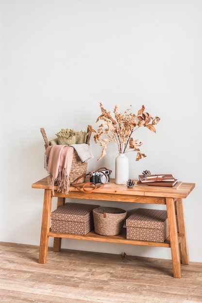 Um banco de madeira uma cesta com folhas de outono xadrez em um vaso de cerâmica um interior de outono aconchegante