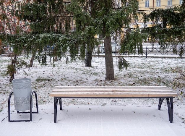 Um banco de parque coberto com a primeira neve