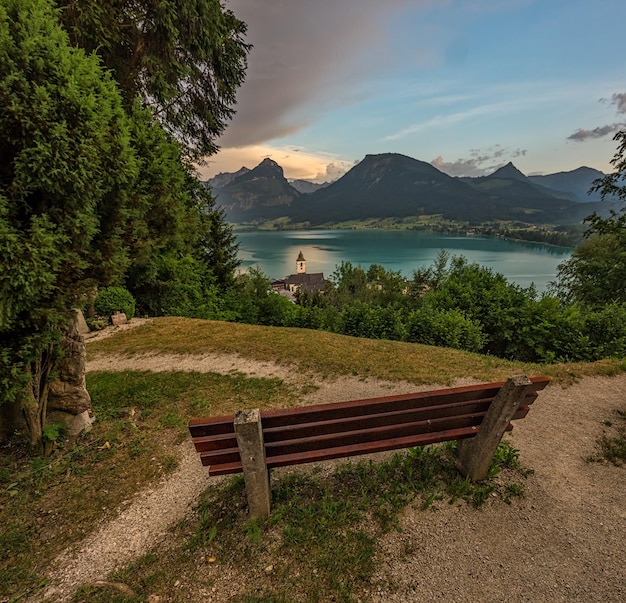 Foto um banco vazio ao lado do lago contra o céu