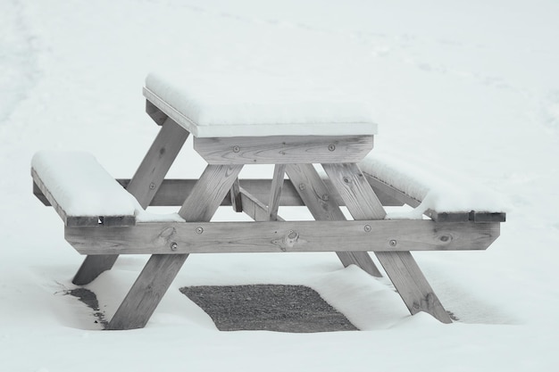 Um banco vazio no parque está coberto de neve