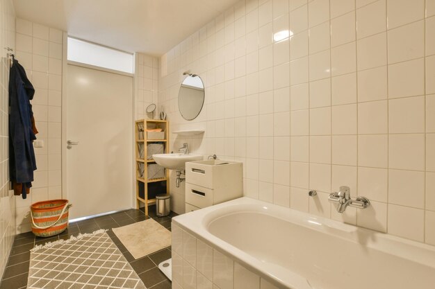 um banheiro com telhas brancas nas paredes e piso preto ao redor do espelho do lavatório e do banheiro