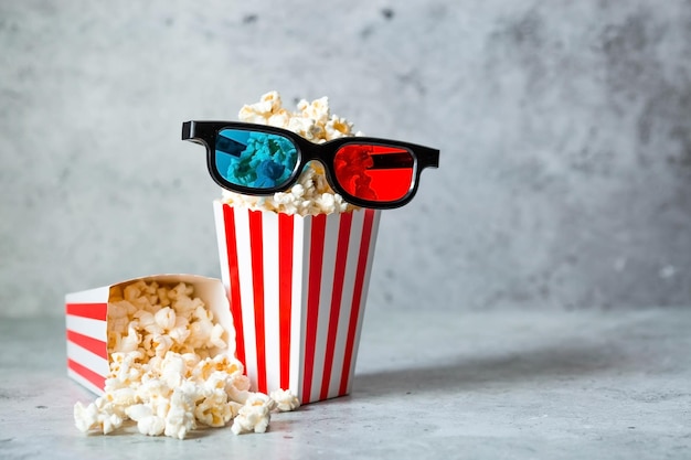 Um banner para a indústria cinematográfica A data de lançamento do filme Óculos 3D e pipoca em copos listrados