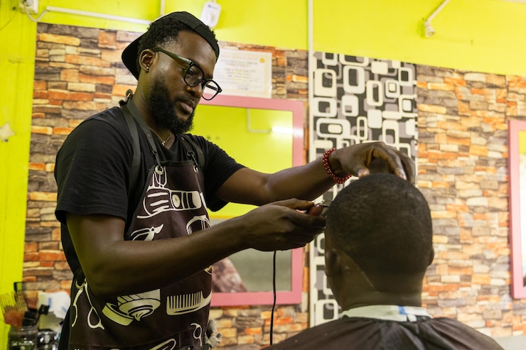 Foto um barbeiro está concentrado em cortar o cabelo de seus clientes em seu salão