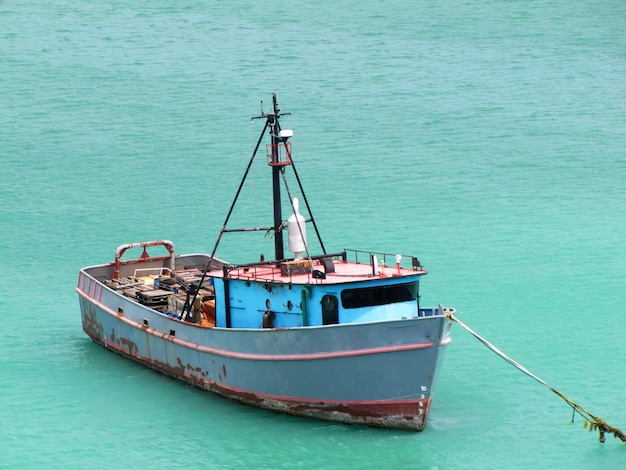Foto um barco de pesca velho e enferrujado ancorado nas caraíbas.