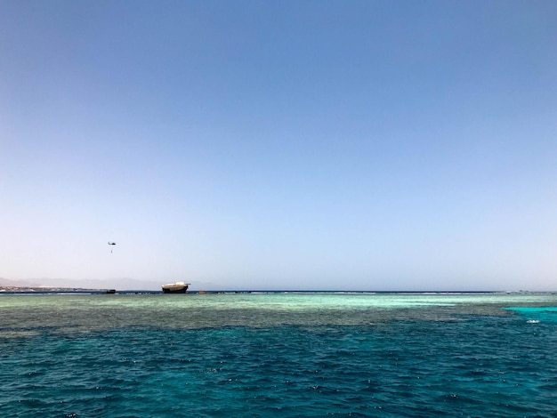 Um barco está no meio de um oceano azul.