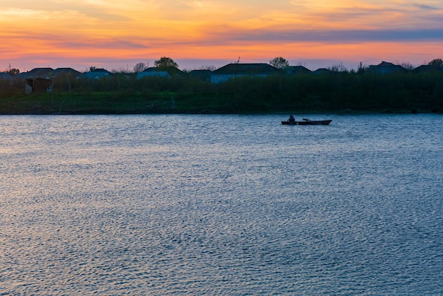 Um barco na água ao pôr do sol