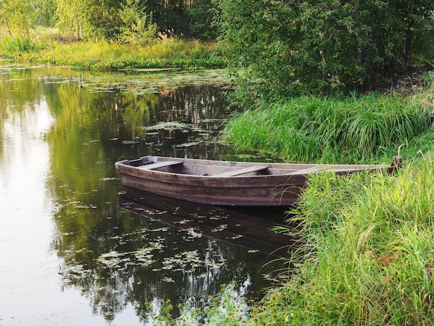 Um barco na margem do rio Uma margem relvada Zona rural