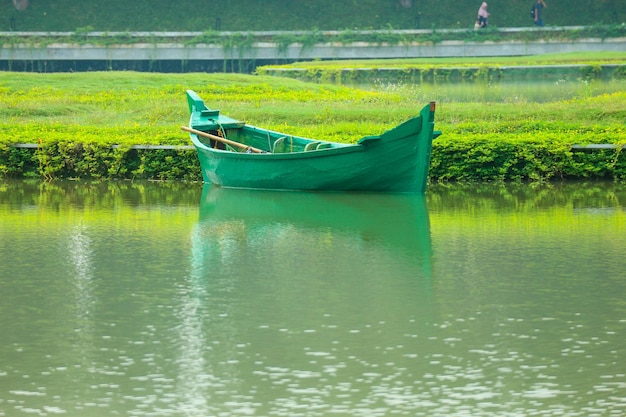 Foto um barco verde sem passageiros estava estacionado na beira do lago