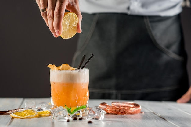 Um barman preparando coquetel com suco de limão