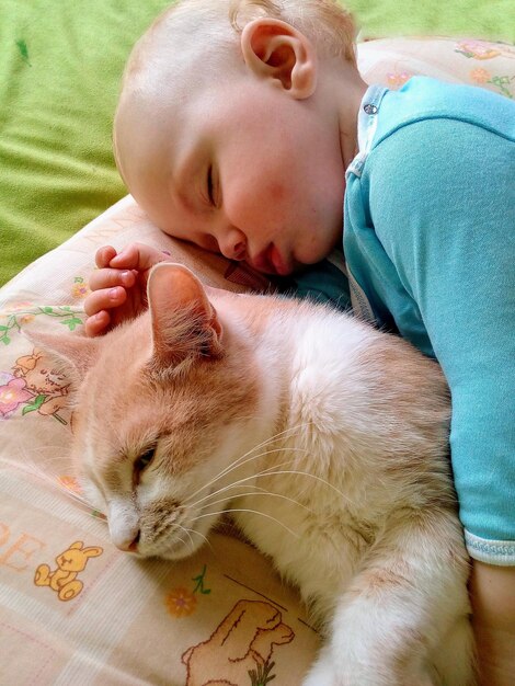 Um bebé bonito a dormir com um gato de brinquedo em casa. Hora de dormir.