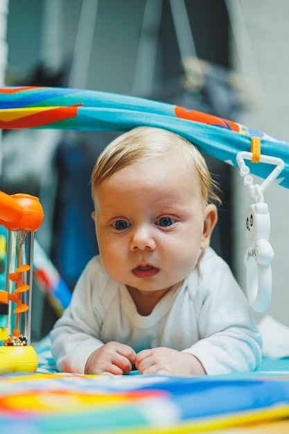 Um bebê brinca em um tapete de desenvolvimento por dois meses Tapete de brinquedo para crianças pequenas