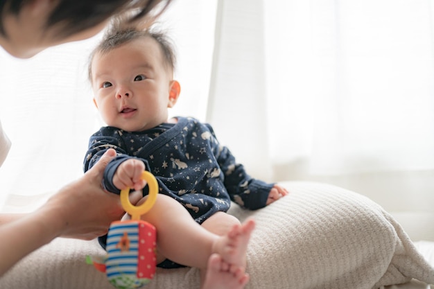 Um bebê com um brinquedo que diz 'bebê' nele