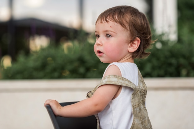 Um bebê de 12 anos com um arranhão na testa olha para o lado