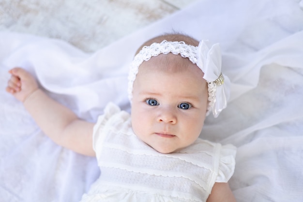Um bebê de olhos azuis olha para a câmera