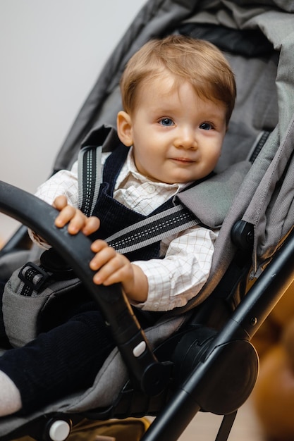 Um bebê em um carrinho está sorrindo e está sentado no chão.