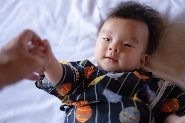 Foto um bebê está deitado em uma cama com uma estrela azul.