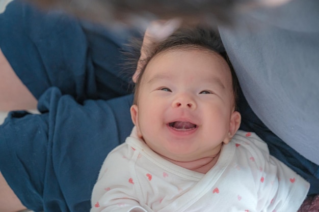 Um bebê feliz sendo acariciado na cabeça