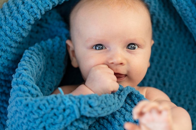 Um bebê fofo abraçando um cobertor azul macio