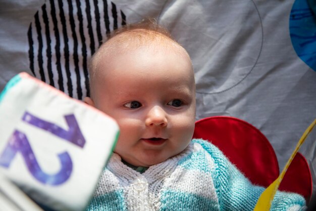 Um bebê fofo brincando em um tapete de atividades de desenvolvimento sensorial