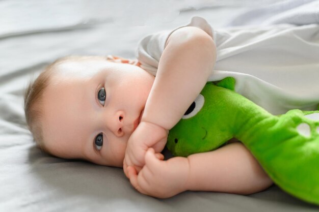 Foto um bebê fofo está deitado no berço com seu brinquedo favorito, conceito de proteção infantil, dia de sono infantil