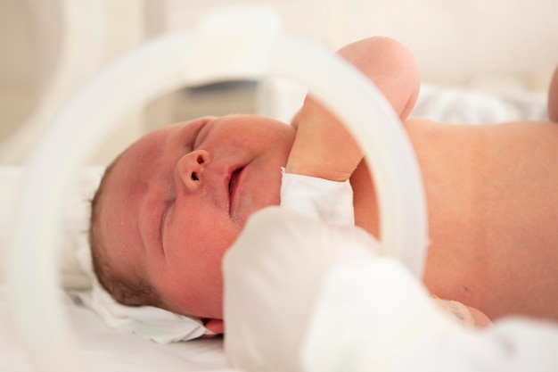 Um bebê recém-nascido encontra-se em caixas no hospital