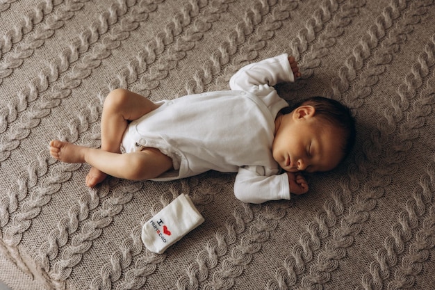 um bebê vestindo uma camisa branca que diz " berço "