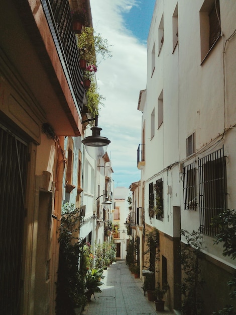 Um beco entre casas contra o céu na cidade