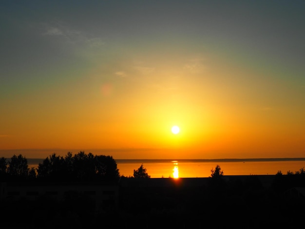 Um belo amanhecer sobre o Lago Onega Karelia O sol em uma névoa dourada sobe acima do horizonte e deixa um caminho brilhante solar na superfície da água