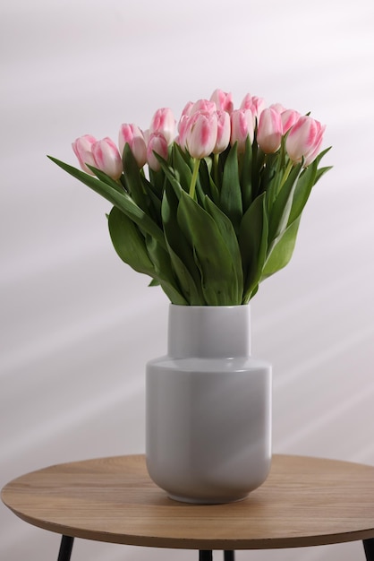 Um belo buquê de tulipas cor-de-rosa frescas na mesa contra um fundo claro