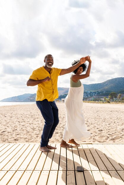 Um belo casal de amantes negros maduros a namorar à beira-mar.