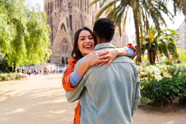 Foto um belo casal feliz de amantes de várias raças namorando na sagrada família de barcelona