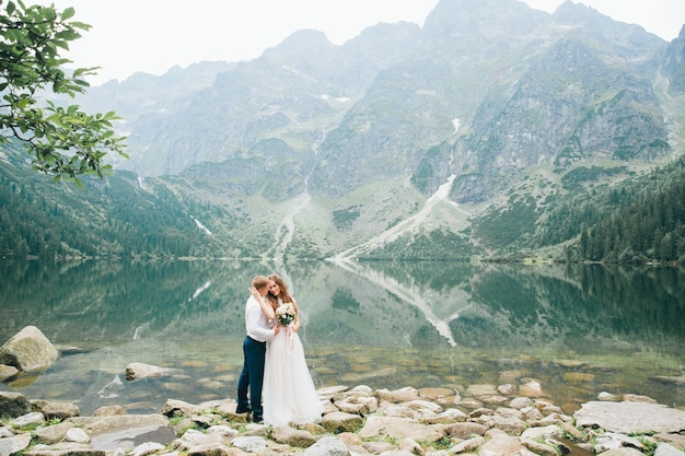 Um belo casal jovem no lago nas montanhas Tatra na Polônia Morskie Oko