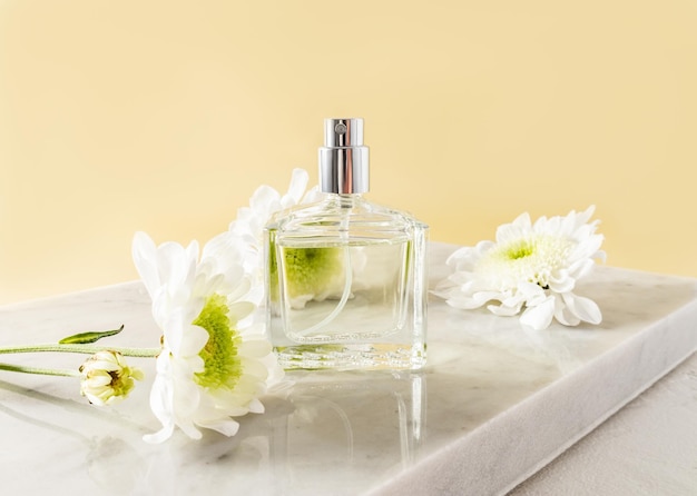 Um belo frasco de perfume ou spray feminino fica em um pódio de mármore branco com vista frontal de flores brancas Um layout vazio para sua fragrância