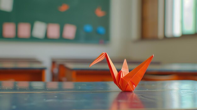 Um belo guindaste origami laranja está sentado em uma mesa em uma sala de aula