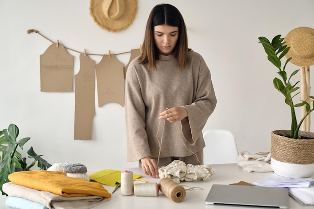 Um belo jovem designer embala uma roupa