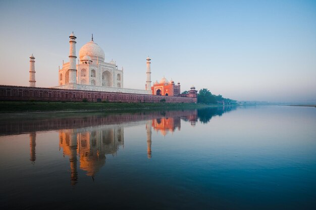 Foto um belo nascer do sol ilumina o lado do taj mahal visto do rio jamuna