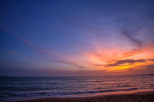 Um belo pôr do sol e praia de areia do mar