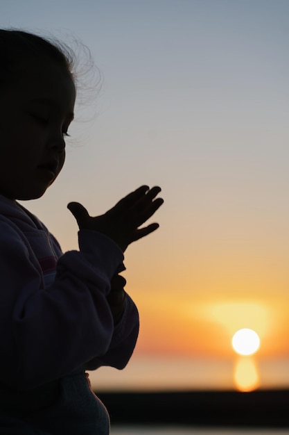 Foto um belo pôr-do-sol no mar com a silhueta de uma criança ao fundo