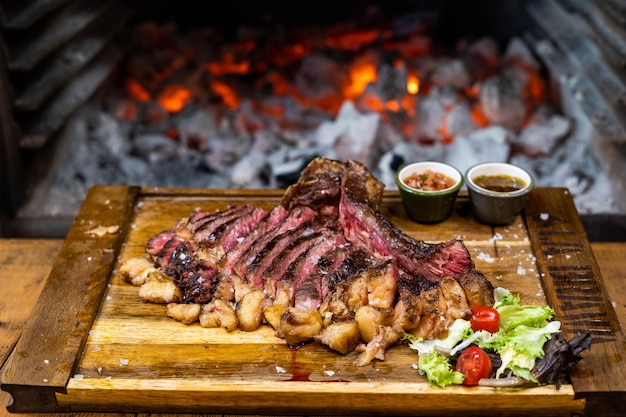 Um bife numa tábua de cortar com um fogo atrás dele.