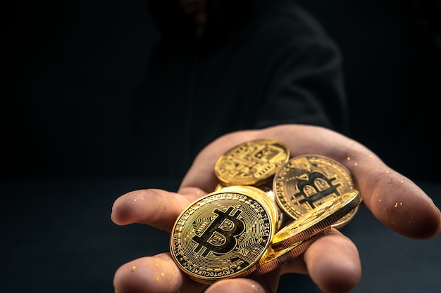 Um bitcoin dourado nas mãos de um homem misterioso, finanças digitais