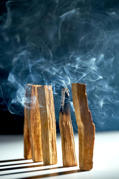 Um bloco de madeira palo santo está queimando fumaça aromática para meditação e cura