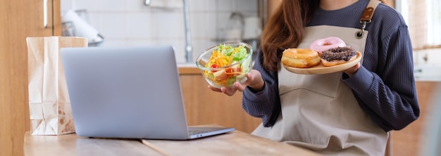 Um blogueiro de vídeo feminino cozinhando comida na cozinha e filmando para o conceito de aula de culinária de aprendizado on-line